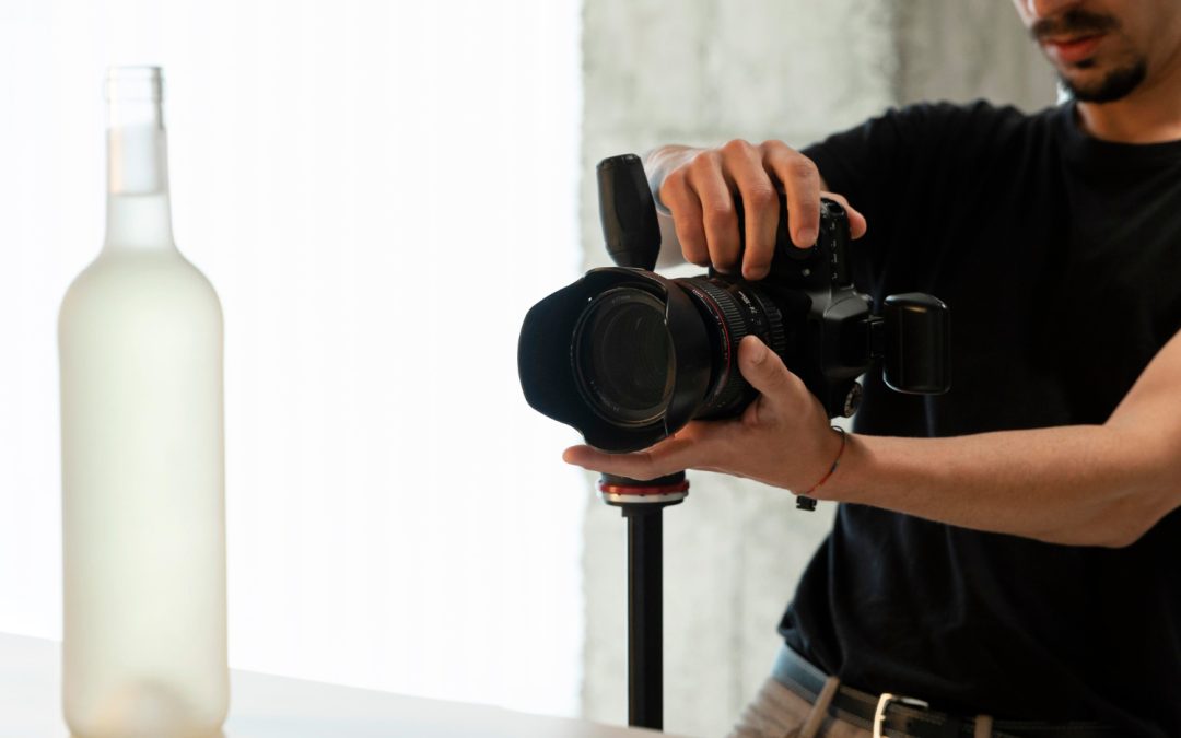 A person takes a photo of a frosted glass bottle with a professional camera on a tripod.